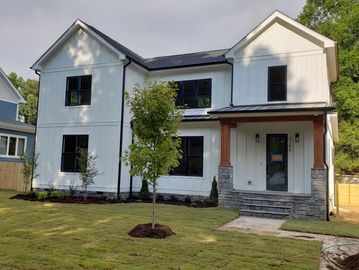 Custom modern white farm house with cedar columns and black windows