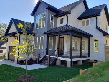 Modern two-story house with a clean, stylish exterior and a small front porch.