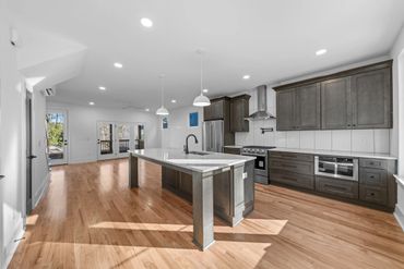 Modern kitchen with a large island and dark cabinetry.