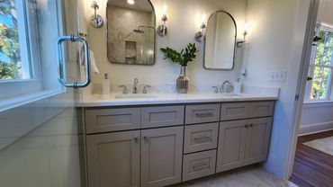 Modern bathroom vanity with dual sinks and large mirrors.