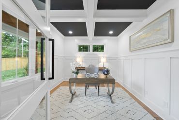 Modern white office with coffered ceiling and large window.