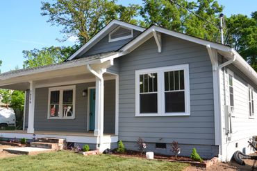 A charming gray single-story house with white trim and a small front porch.