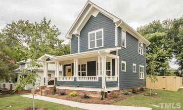 Two-story blue house with a front porch and white trim.
