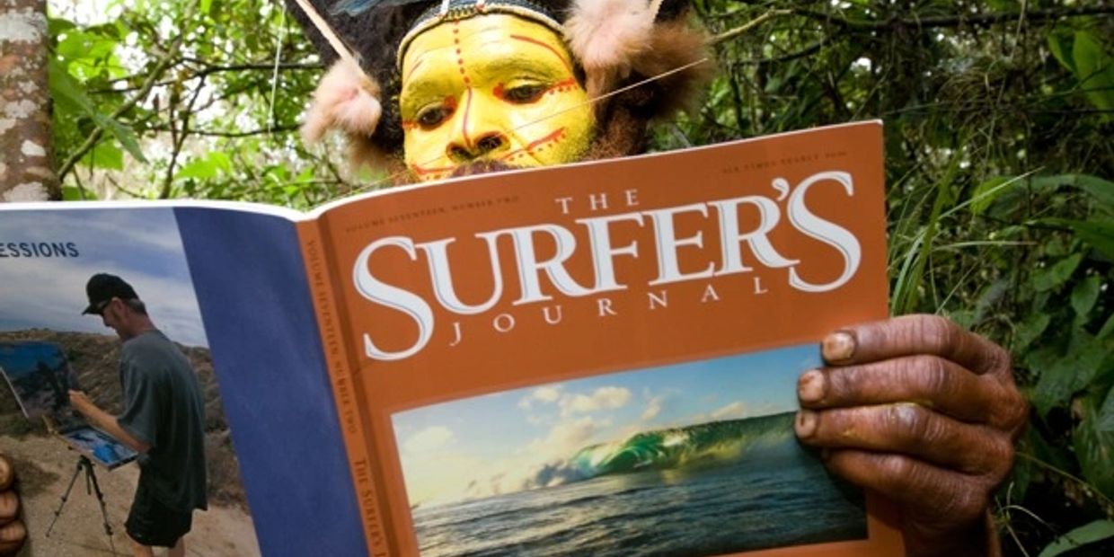 Person in traditional face paint reading The Surfer's Journal.