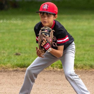 Young baseball player in ready position on field.