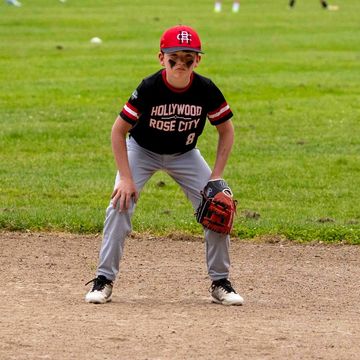 Young baseball player in ready position on field.