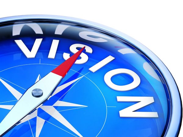 A blue compass pointing towards the word 'VISION'.