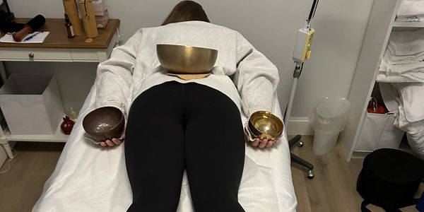 individual in a one on one sound therapy session with Tibetan Singing bowls on her body