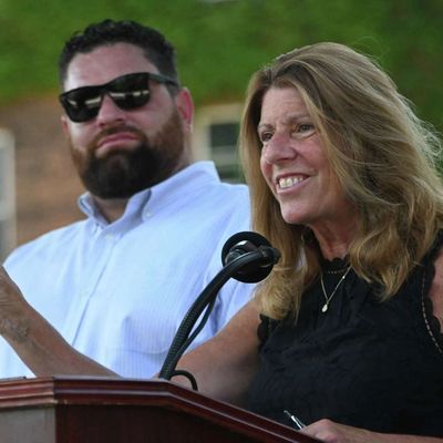 Woman speaking at podium with a man beside her.