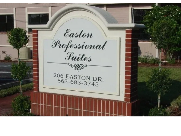 This sign is brick, and backlit acrylic, sitting in a nicely manicured yard.