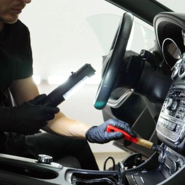 Persona limpia y revisa el interior de un automóvil.