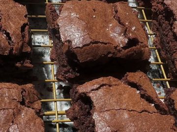 Freshly baked chocolate brownies cooling on a wire rack.