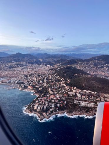 Aerial view of a coastal city with mountains in the background.