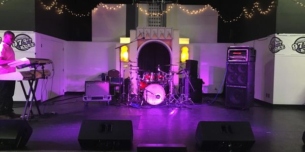 Stage setup with musical instruments and purple lighting ready for a live performance.