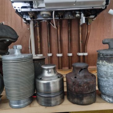Various metal calibration weights on a wooden shelf.