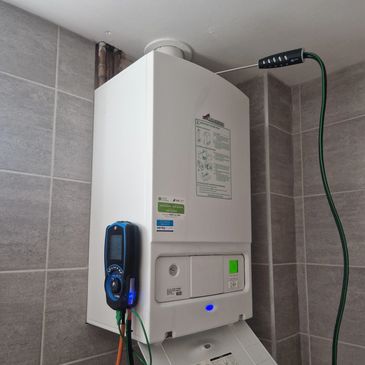 Modern white boiler with control panel and attached devices.