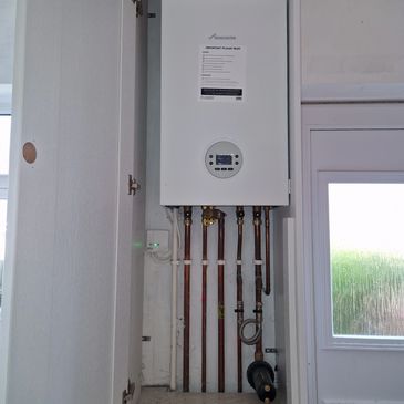 Wall-mounted boiler with visible pipes and controls.