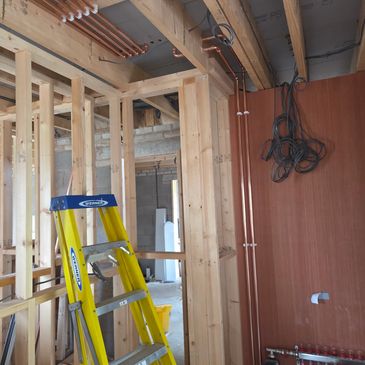 Wooden frames and electrical wiring in construction site with ladder.