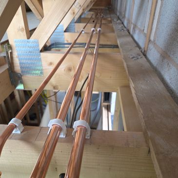 Three copper pipes installed horizontally.