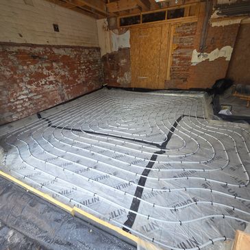 Underfloor heating pipes installed in a room under renovation.