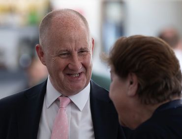 Two people engaged in a warm conversation, one smiling broadly.