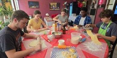 KGroup of kids making homemade pasta from scratch.