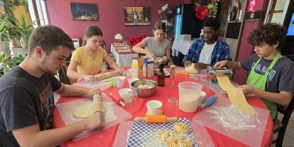 KGroup of kids making homemade pasta from scratch.