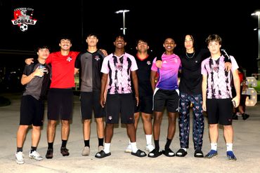 A group of eight young men posing together at night, wearing sports attire with Cooper City Cobras logos.