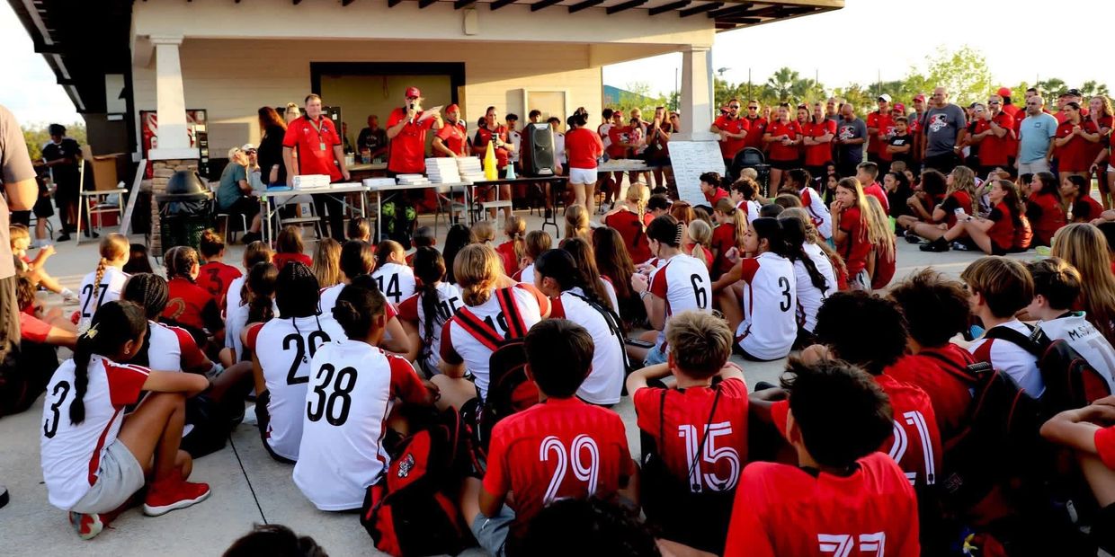 Youth sports team gathered for an outdoor awards ceremony.