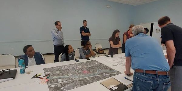 Group discussing a large map at a meeting table.