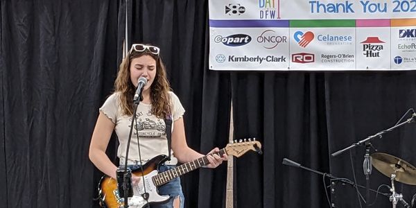 vocal lesson and guitar lesson student at a live performance