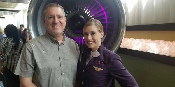 Male and female in front of an airplane engine 