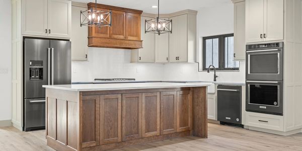 Modern kitchen with wooden island and stainless steel appliances.