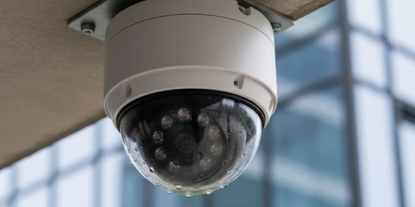 Dome security camera mounted on a building ceiling.