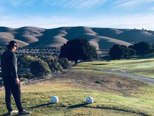 playing footgolf with a soccer ball on a golf course