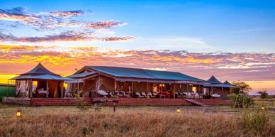 Sunset view of a luxury safari lodge with outdoor seating in the wild.