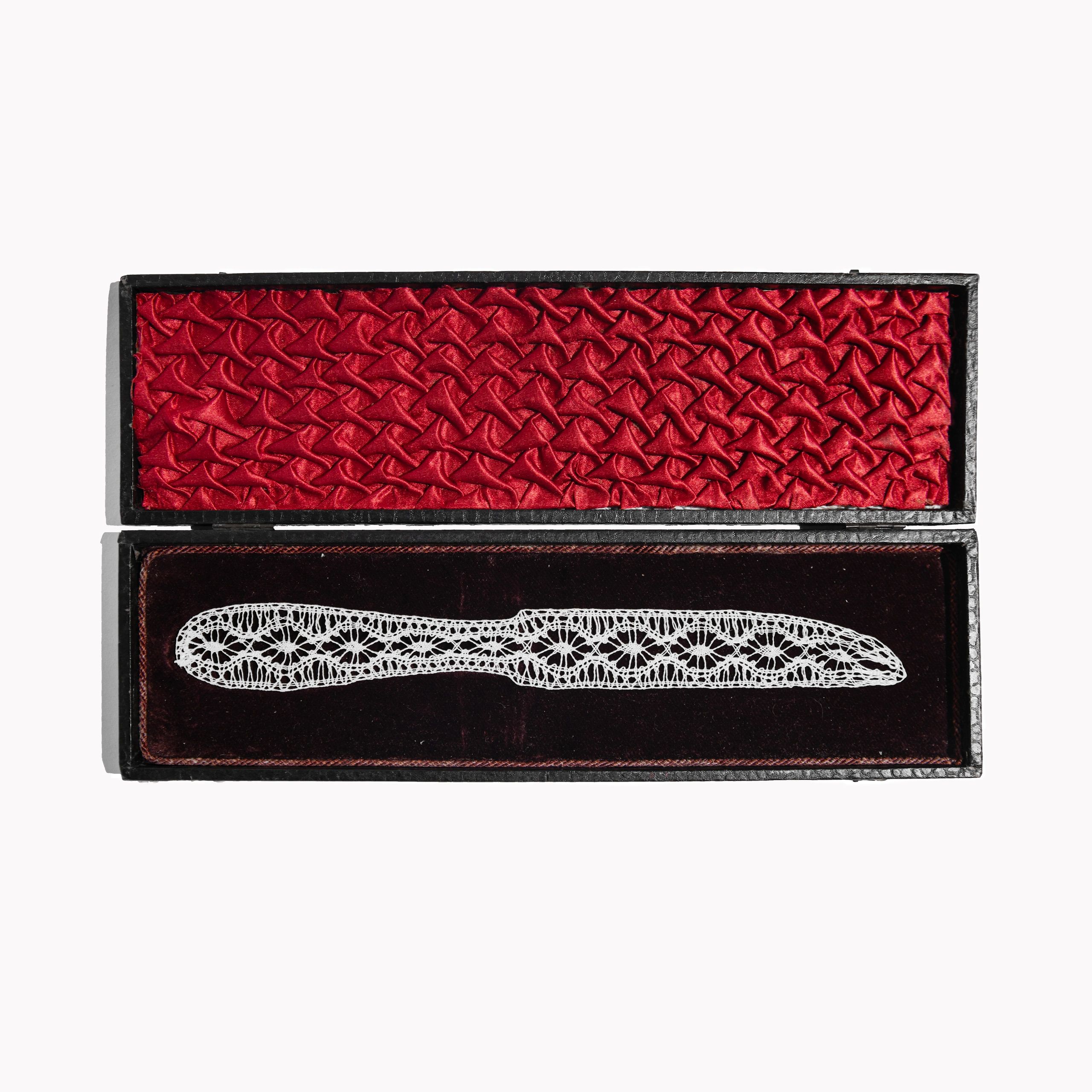 Delicate lace knife in a red velvet box.