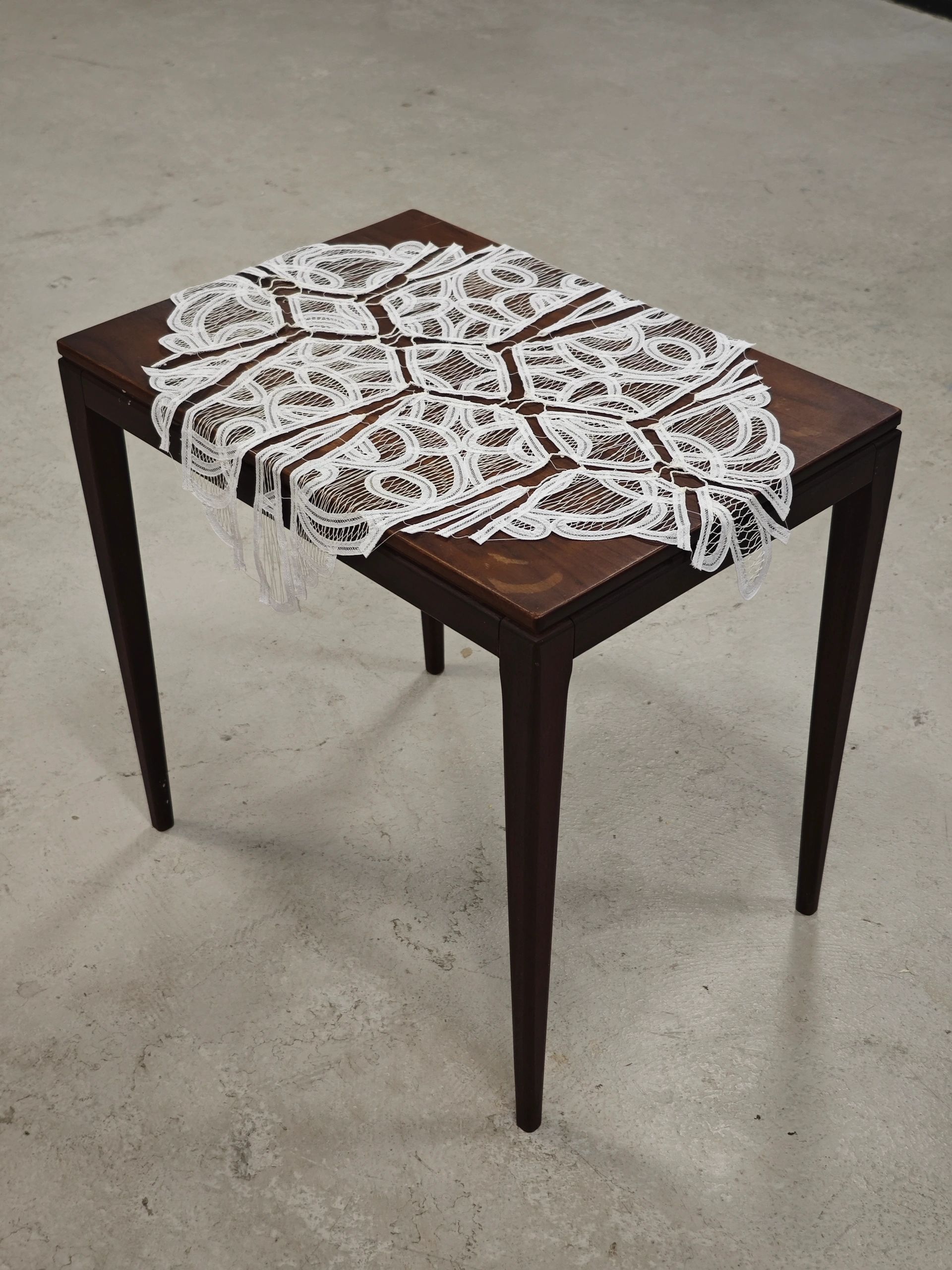 Dark wooden table with a white lace table runner.