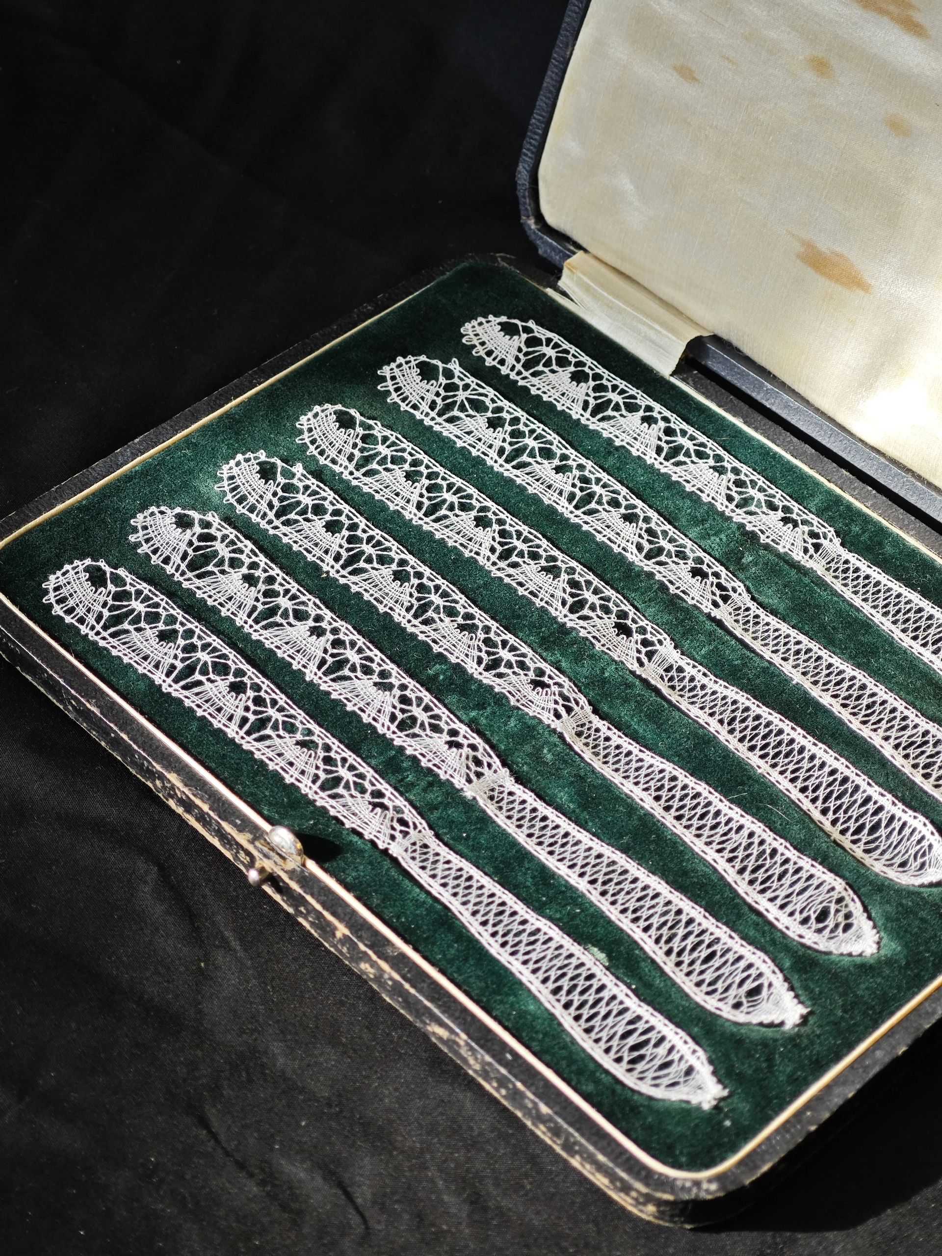 Intricate lace strips in a velvet-lined case.