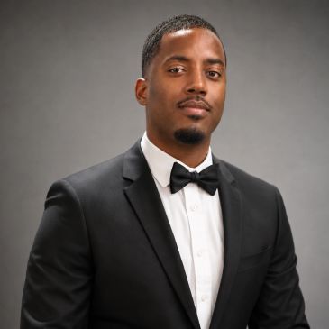 Man in black tuxedo with bow tie.