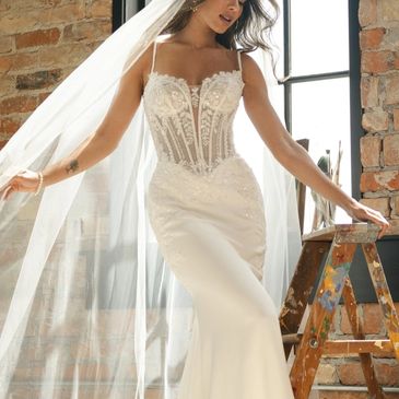 Bride in elegant wedding dress with intricate lace and veil.