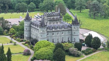 A grand castle surrounded by lush greenery and gardens.