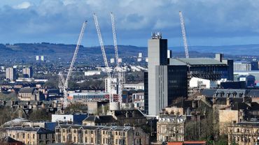 Urban cityscape with several construction cranes and tall buildings.