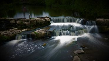 A serene waterfall cascading over rocks in a forested area.