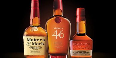 Three bottles of Maker's Mark bourbon whiskey with red wax seals.