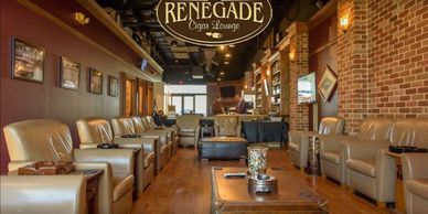Luxurious leather seating in Renegade Cigar Lounge with warm lighting and wooden accents.