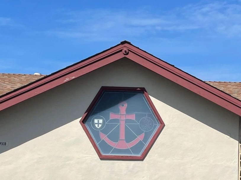 Hexagonal window with anchor design on house facade.