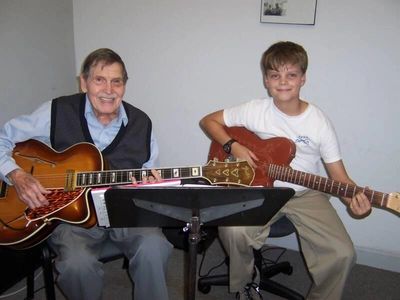 Charlie Wood, having a guitar lesson with a young student. 