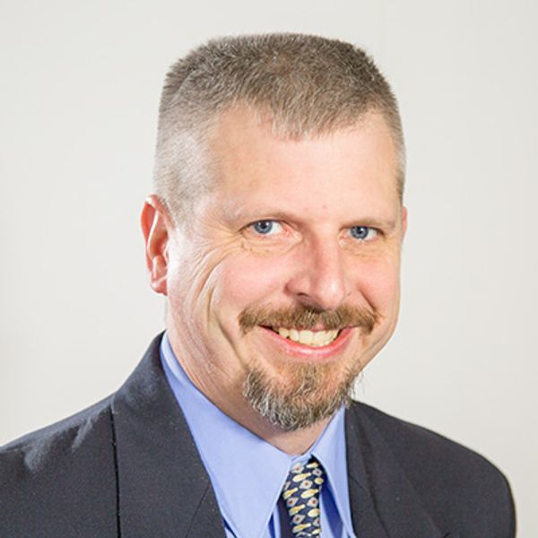 Man in suit smiling.