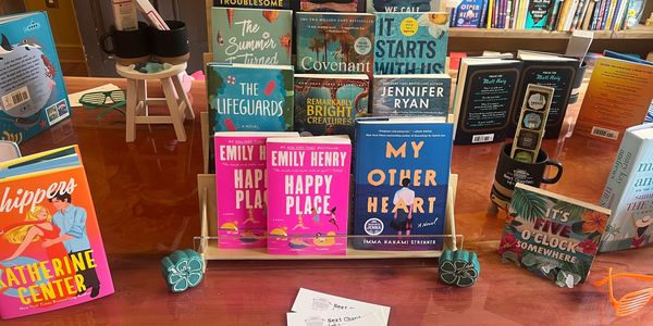 Books displayed on a wooden table in a bookstore.